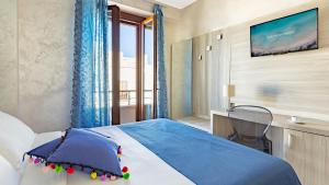 圣维托罗卡波皮克罗蒙德酒店的一间卧室配有一张床,墙上配有电视