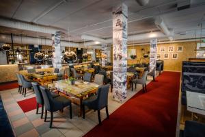 托尔尼奥Grand Hotel Mustaparta的餐厅设有木桌和椅子,铺有红地毯