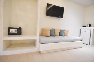 佩里萨海浪酒店的一间设有沙发的客房,墙上配有电视