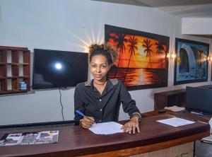 贝岛Hotel La Bombonera的坐在一张写着一张纸的桌子上的女人