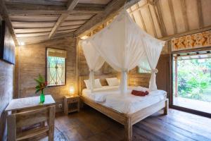 坎古潘德寄宿家庭式酒店的一间卧室配有一张带蚊帐的床