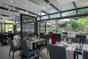 布里尼奥勒布里尼奥勒普罗旺斯韦尔特宜必思酒店的餐厅设有桌椅和窗户。