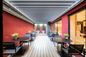 巴塞罗那加泰罗尼亚米卡多酒店的一间设有桌椅和红色墙壁的餐厅