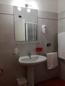 马内尔巴Bellerive Ristorante Albergo的浴室配有盥洗盆、镜子和毛巾