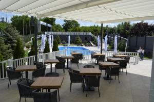 第聂伯罗路德斯塔酒店的一个带桌椅的户外庭院和一个游泳池
