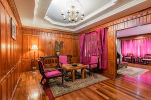 暹粒Empress Angkor Resort & Spa的一间带桌子和粉红色椅子的用餐室