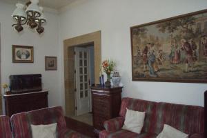 圣玛尔塔迪佩纳吉昂格兰德塞拉多旅馆的客厅配有两把椅子和墙上的绘画