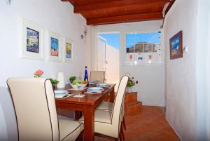 MáguezEco Casa Atalaya的一间带木桌和白色椅子的用餐室