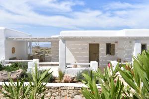 普恩达Ciel Villas Paros的白色的房子,配有白色家具和植物
