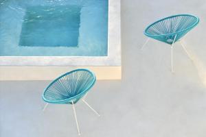 普恩达Ciel Villas Paros的两把蓝色椅子坐在游泳池旁