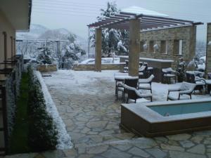 约阿尼纳杜维尔特精品酒店的一座配有桌椅的雪地庭院