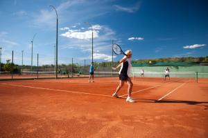 弗尔萨尔Koversada Apartments Naturist Park的一群人在网球场打网球