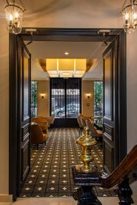 巴黎乐诺巴纳斯峰酒店的走廊上设有门,通往带椅子的房间