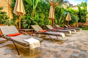 非斯拉劳斯赛酒店的庭院里摆放着一排躺椅和遮阳伞