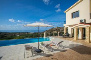佩亚Villa Blue Jadeite的一个带遮阳伞和椅子的庭院和一个游泳池