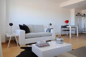 里斯本全景生活公寓的客厅配有白色的沙发和桌子