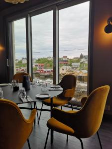 索尔瓦根The Tide - Rorbuer的一间带桌椅和窗户的用餐室