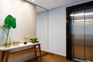 维多利亚-达孔基斯塔Dr. Marinho Apart Hotel的一间设有玻璃门和植物桌子的房间