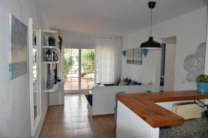桑帕克Els Vents, tu apartamento junto al mar en Son Parc的厨房以及带沙发和桌子的客厅。