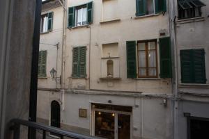 萨尔扎纳Le Camere Di Boccanegra的一座带绿色百叶窗和商店前的建筑