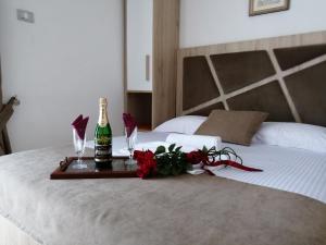 乌尔齐尼Apartments Gazi的床上的托盘,包括一瓶香槟和鲜花