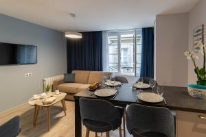 圣马洛Appartements des Marins的用餐室以及带桌椅的起居室。