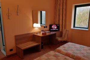 福萨诺罗曼尼西欧酒店的酒店客房配有一张书桌、一台电视和一张床