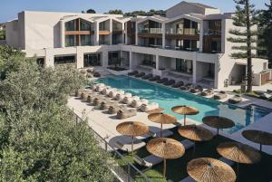 蒂锡利维孔特西纳酒店的一个带遮阳伞和椅子的游泳池和一座建筑