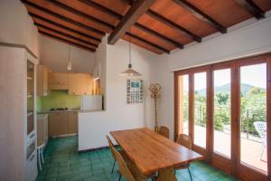 拉科纳Residence le Mimose的一间带木制餐桌的厨房和一个阳台