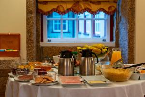 巴罗塞拉斯金塔乡德圣塞巴斯蒂昂酒店的一张桌子,上面有食物放在白色桌布上