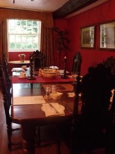 米德尔赫姆Braithwaite Hall Bed & Breakfast的一间设有木桌和红色墙壁的用餐室