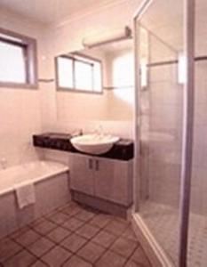 北克莱顿克莱顿莫纳什汽车旅馆&服务公寓的浴室配有盥洗盆、浴缸和盥洗盆