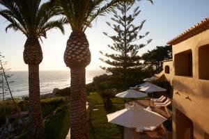 阿尔布费拉维拉霍亚酒店的两棵棕榈树,带遮阳伞,大海
