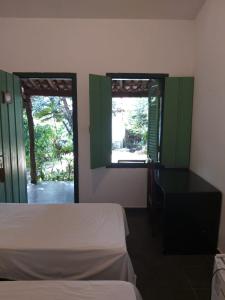 戈亚斯Pousada do Ipe的一间卧室配有一张床、一张书桌和两个窗户。