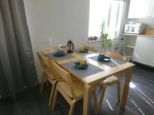 伊马特拉Vuoksi Apartment的一张带四把椅子的木桌和一张带食物的桌子