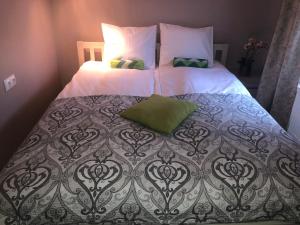 塔林Villa Kadriorg Hostel的一张配有白色床单和绿色枕头的大床
