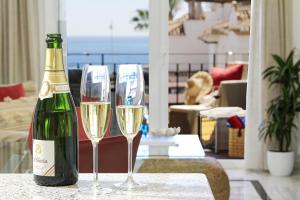 拉海瑞德拉Casa de la playa Alto de el Realengo的桌子上放有一瓶香槟和两杯酒杯