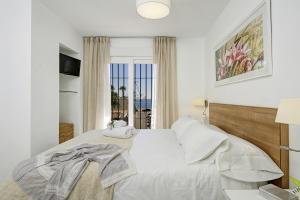 拉海瑞德拉Casa de la playa Alto de el Realengo的白色的卧室设有床和窗户