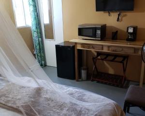 安东尼奥港Viva Violas的一间卧室配有一张床,书桌上设有微波炉