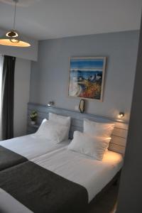 圣皮耶尔基贝龙Hotel De Bretagne的一间卧室配有带白色床单和枕头的床。