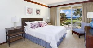 科洛阿坡伊普捕鲸湾酒店的一间卧室设有一张床,享有海景