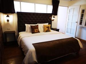 库斯科Cities of the World - Apartments Cusco的卧室配有一张带白色床单和枕头的大床。