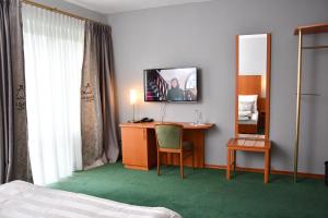 LengedeLANDHAUS LENGEDE Hotel的酒店客房设有一张桌子和一台墙上的电视