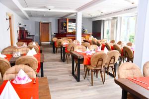 LengedeLANDHAUS LENGEDE Hotel的用餐室配有桌椅和红色餐巾