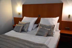 LengedeLANDHAUS LENGEDE Hotel的一张带白色床单和枕头的床