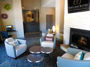 布卢明顿Eastland Suites Hotel & Conference Center的酒店大堂设有椅子和壁炉。