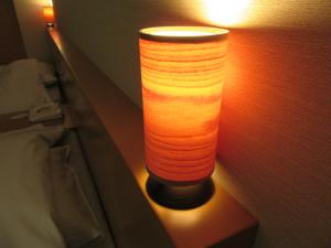 FukauraKoganezaki Furofushi Onsen的床头墙上的一盏灯