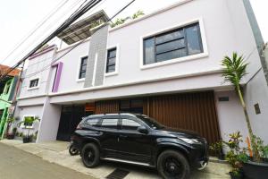 PangkalanuringinWisma Surya的停在房子前面的一辆黑色汽车