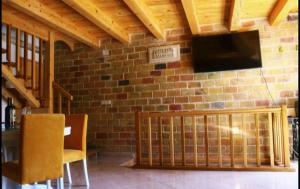 拉斯托伏Accommodation Santor的一间设有砖墙、电视和椅子的房间