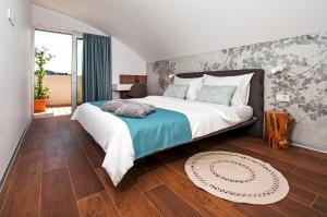 罗维尼The Q - Superior Apartment的一间卧室设有一张大床,铺有木地板。